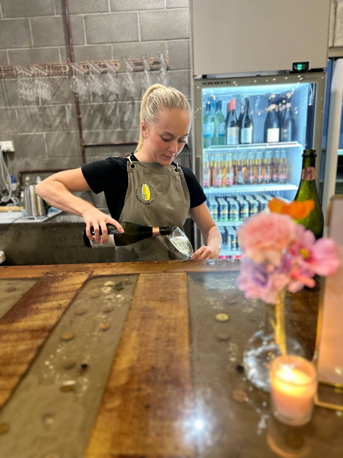 The Salty Lime Co team member pouring sparkling wine at the venue bar
