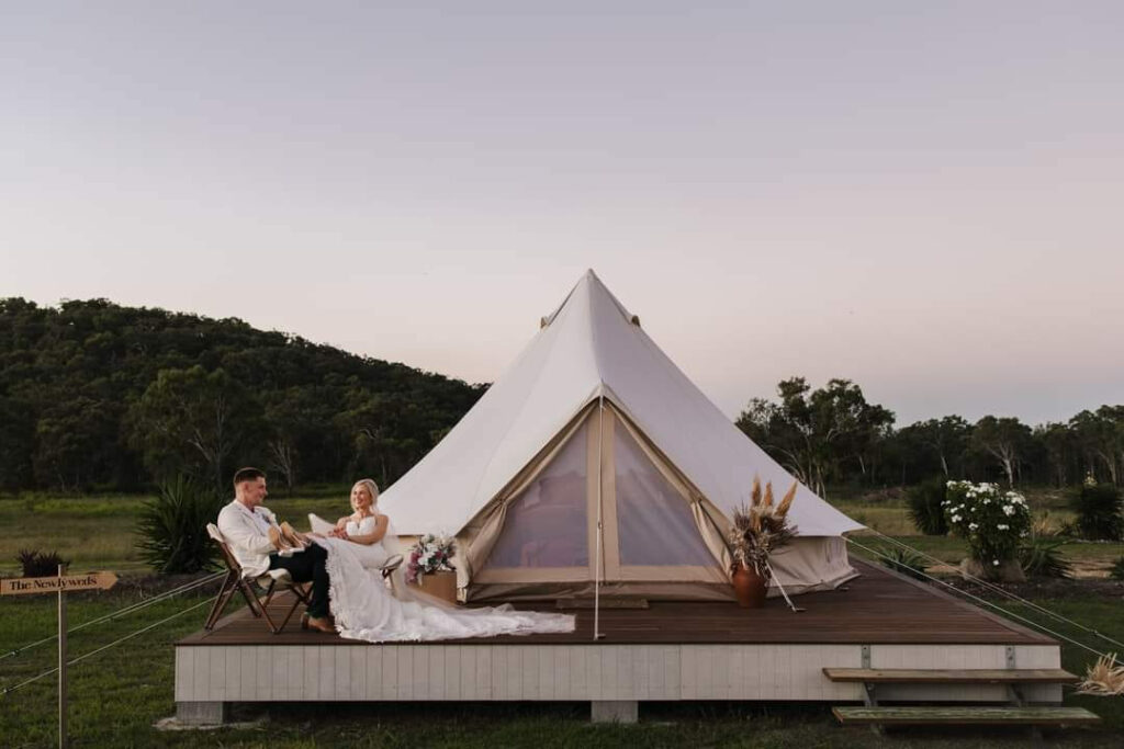 Couple relaxing on the deck of a luxury glamping bell tent