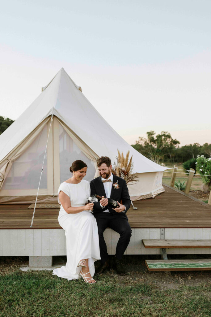 Newlyweds beside a luxury glamping tent at The Salty Lime Co