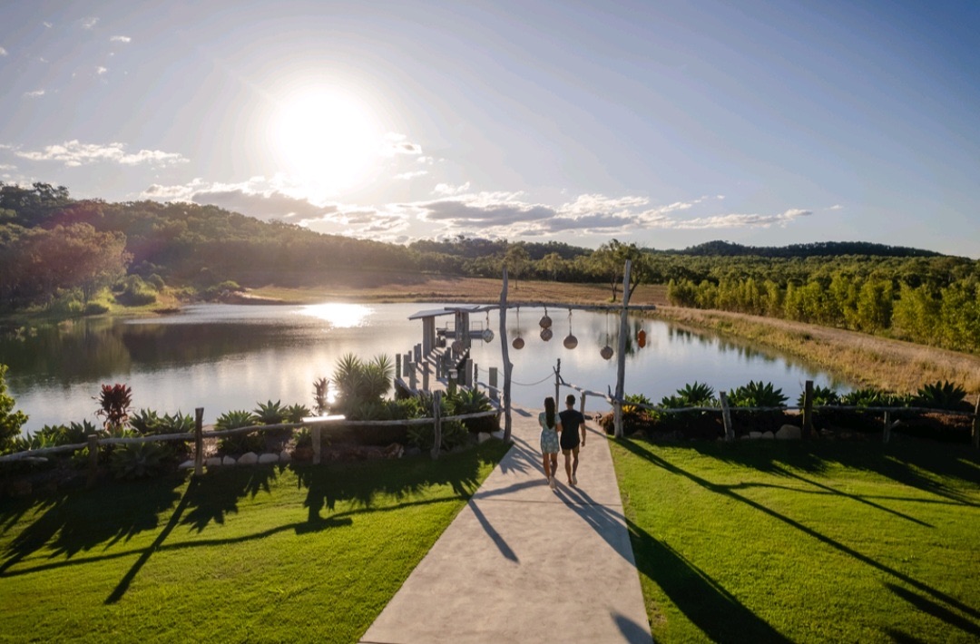Guests walking towards the lakeside garden at The Salty Lime Co near sunset
