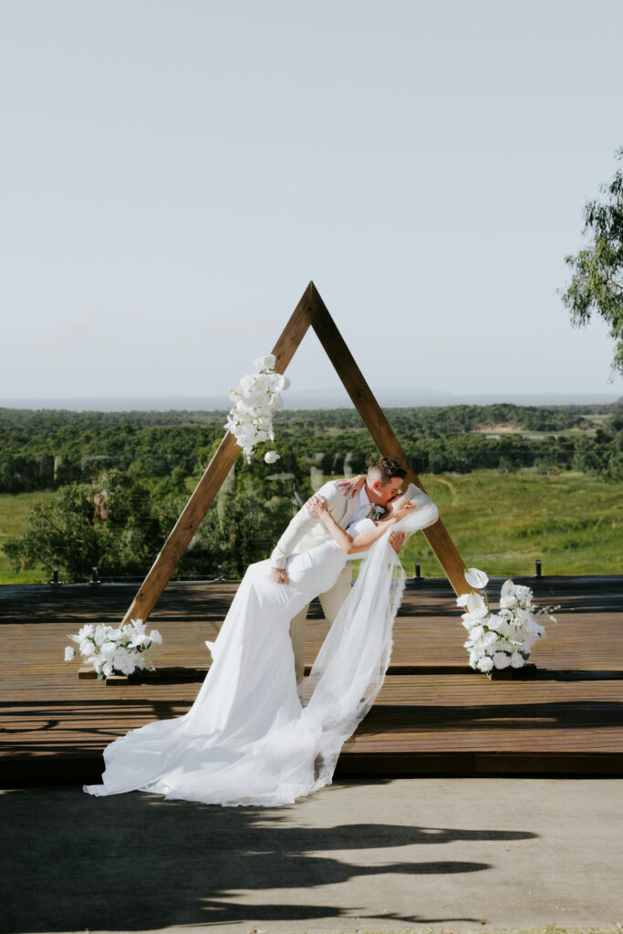 Bride and groom beneath the ceremony arbour