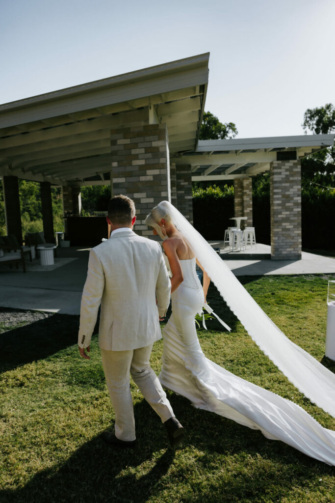 Newlyweds walking together across the venue lawn