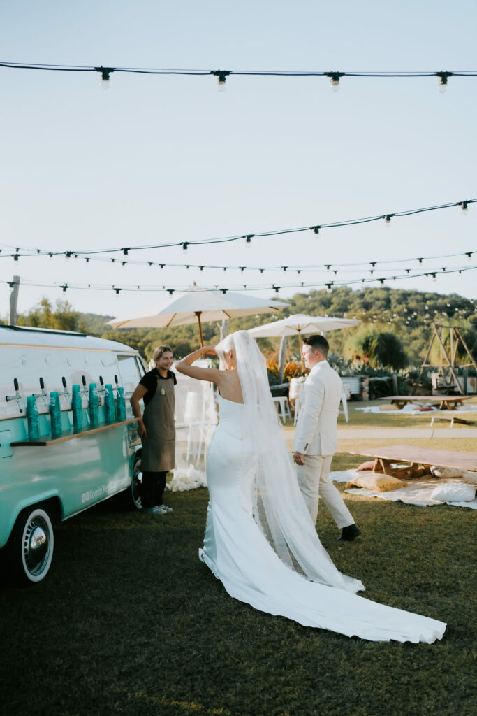 Bride celebrating beside the vintage wedding van