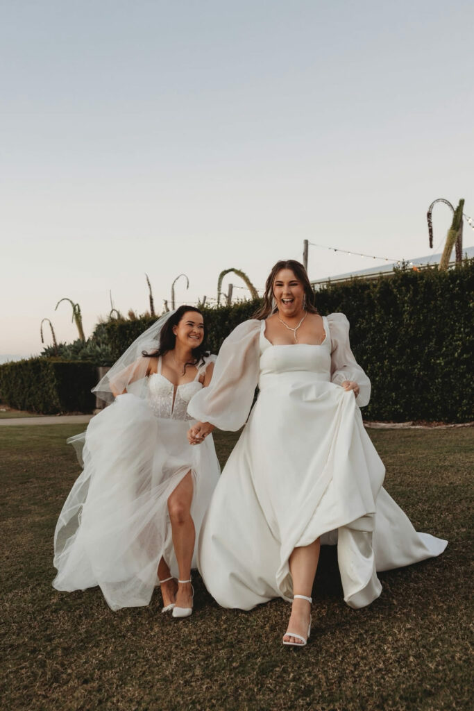 Bride and bridesmaid celebrating beside the lake