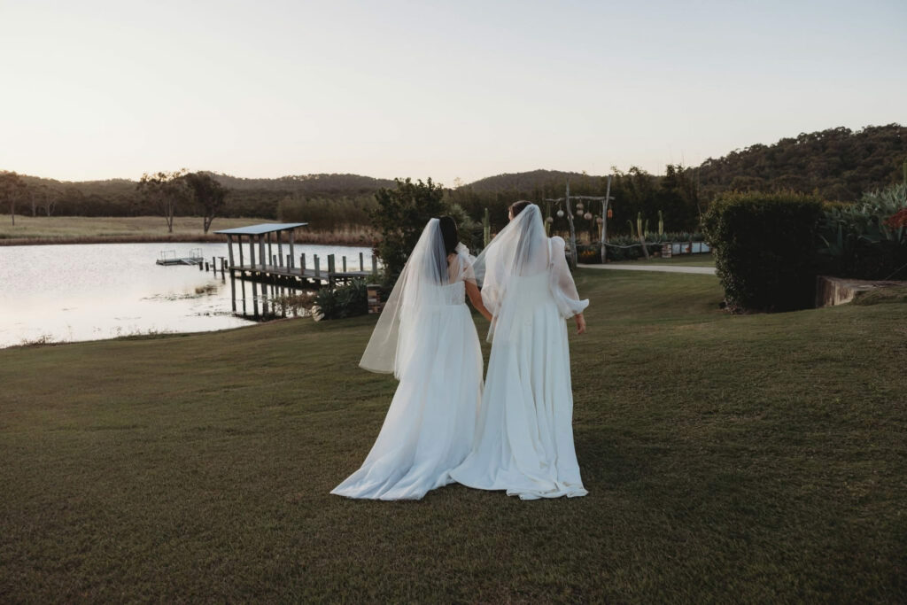 Brides sharing a lakeside wedding moment