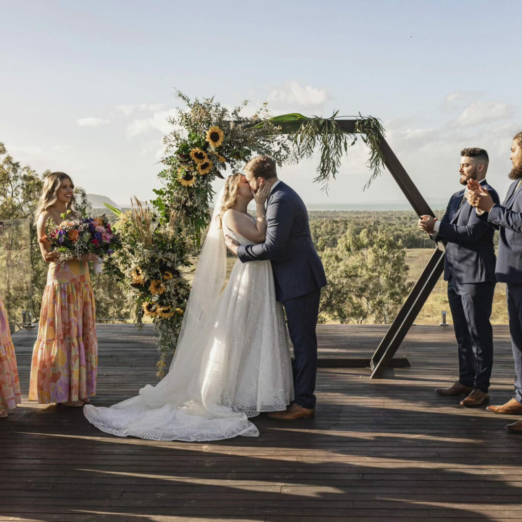 Newlyweds beneath a floral ceremony arbour