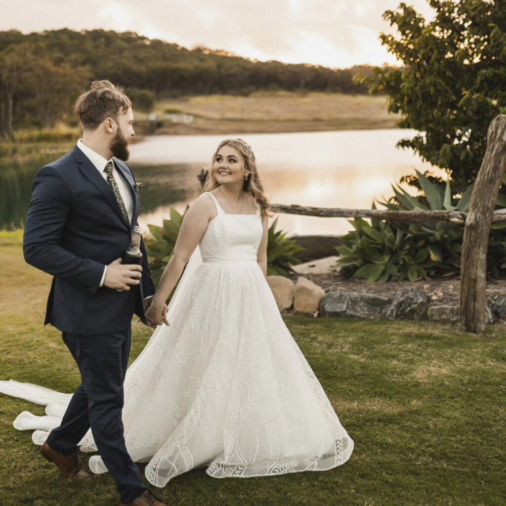 Newlyweds walking beside the lake at The Salty Lime Co