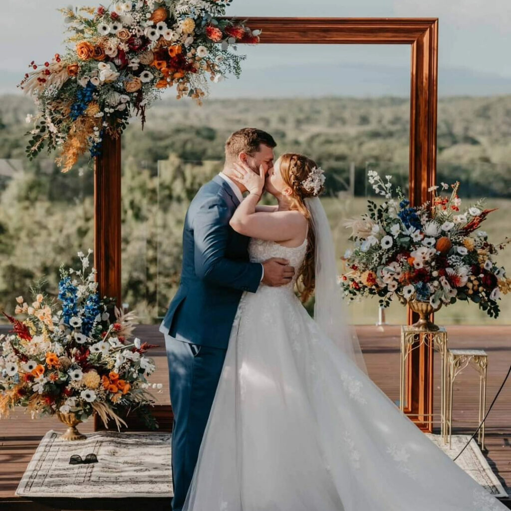 Wedding couple beneath a colourful floral frame