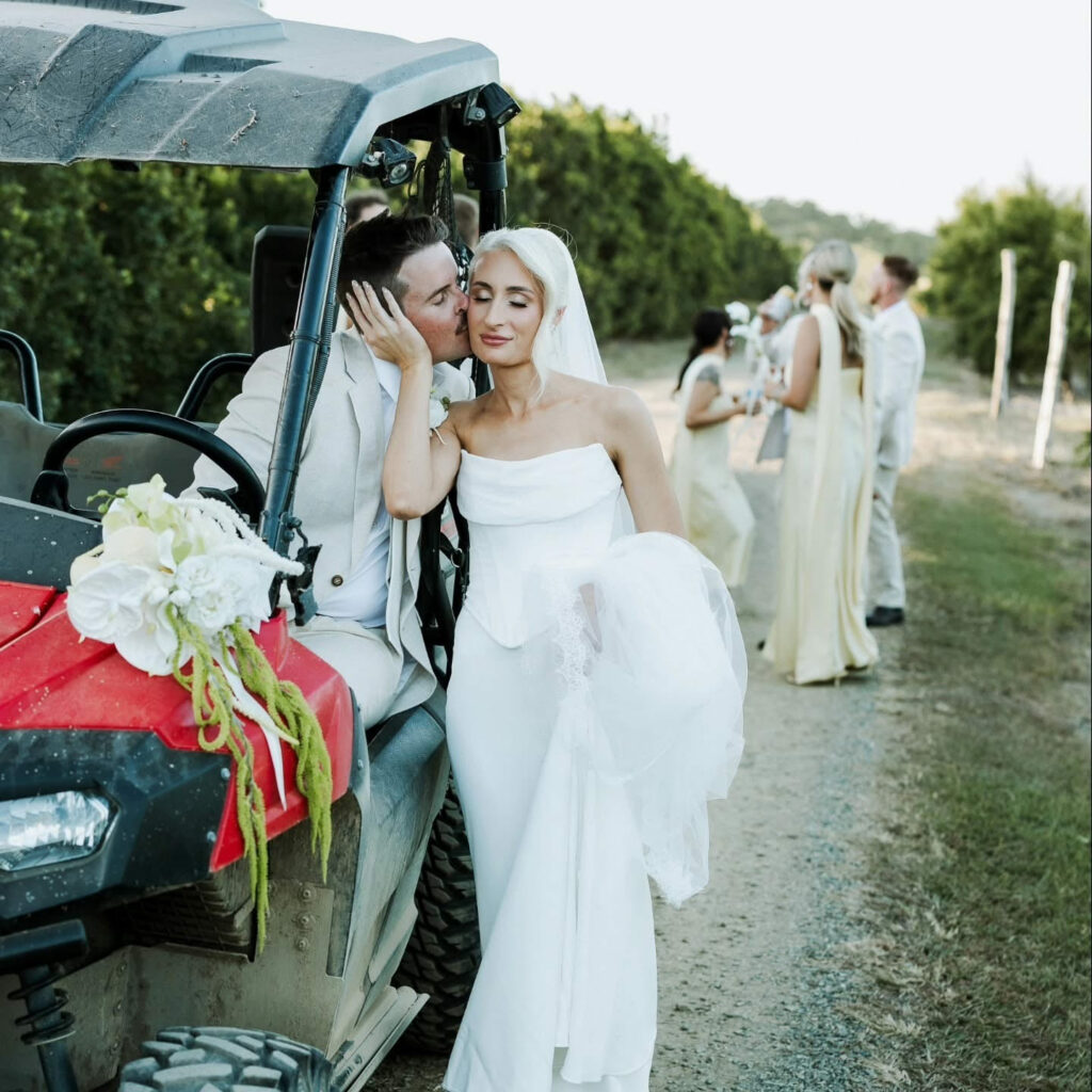Bride arriving beside a vintage wedding car